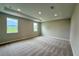 Spacious primary bedroom featuring tray ceilings, neutral carpeting, and natural light from large windows at 780 Pointe Emerson Blvd, Apopka, FL 32703