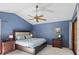 Comfortable blue bedroom featuring a tray ceiling, ceiling fan, and a set of bedside tables at 9532 Bay Vista Estates Blvd # 1, Orlando, FL 32836