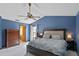 Spacious bedroom with a blue accent wall, a cozy bed, and a view into the en-suite bathroom at 9532 Bay Vista Estates Blvd # 1, Orlando, FL 32836