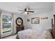 Bright bedroom featuring a ceiling fan, window overlooking the yard, and decorative furniture at 9532 Bay Vista Estates Blvd # 1, Orlando, FL 32836