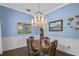 Elegant dining room with a crystal chandelier, wood table and blue accent walls at 9532 Bay Vista Estates Blvd # 1, Orlando, FL 32836