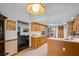 Bright kitchen with wooden cabinets, tile floors, and seamless transition to the living room at 9532 Bay Vista Estates Blvd # 1, Orlando, FL 32836