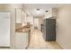 Galley kitchen with white cabinets, granite countertops, and stainless steel appliances at 996 E Normandy Blvd, Deltona, FL 32725