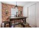 Cozy dining area with a rustic table, industrial pendant lighting, and brick accent wall at 1230 Woodlark Dr, Haines City, FL 33844