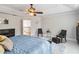 Spacious bedroom with a fan, blue bedding, a sitting area, and decorative wall accents at 1037 Truffles Ct, Apopka, FL 32712