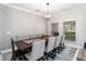 Elegant dining room with a large table, seating for ten, decorative wall paneling, and a stylish chandelier at 1037 Truffles Ct, Apopka, FL 32712