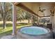 Covered outdoor space featuring a hot tub and comfortable seating with views of the grassy backyard at 1037 Truffles Ct, Apopka, FL 32712