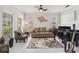 Bright living room featuring a grand piano, plush seating, and stylish decor accents at 1037 Truffles Ct, Apopka, FL 32712