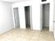 Bedroom featuring neutral paint, tiled floors and ample closet space at 1100 E Caroline St # 119, Tavares, FL 32778