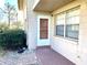 Exterior view of the home entrance with security screen door and adjacent garden area at 1100 E Caroline St # 119, Tavares, FL 32778