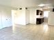 Open-concept living room and kitchen featuring tile flooring and neutral paint at 1100 E Caroline St # 119, Tavares, FL 32778