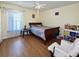 Cozy bedroom with hardwood floors, ceiling fan, bright natural light, and stylish decor at 12017 Fambridge, Orlando, FL 32837
