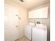 Laundry room with white cabinets above washer and dryer at 12017 Fambridge, Orlando, FL 32837