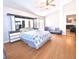 Bright main bedroom with a ceiling fan, wood floors, large bed, and access to an ensuite bathroom at 12017 Fambridge, Orlando, FL 32837
