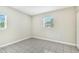 An empty bedroom showcasing light gray walls and tile flooring, with natural light from a window at 1202 Ferndell Rd, Orlando, FL 32808