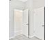 Hallway view showcasing light gray walls, tile flooring and doors throughout the home at 1202 Ferndell Rd, Orlando, FL 32808