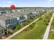 Aerial view of a neighborhood featuring two-story homes, green lawns, sidewalks, and a red balloon at 12051 Walmsley Aly, Winter Garden, FL 34787