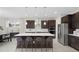 Modern kitchen featuring a large island, stainless steel appliances, and pendant lighting at 13154 Pergola Ave, Orlando, FL 32832