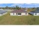 The backyard has an expansive lawn, with a house with multiple windows and a brown roof at 15240 Sw 43Rd Ct, Ocala, FL 34473