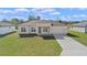 The exterior of this home features a paved driveway and lush green grass at 15240 Sw 43Rd Ct, Ocala, FL 34473