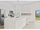 Bright kitchen boasts stainless steel appliances, white cabinets, pendant lighting, and a large kitchen island at 15240 Sw 43Rd Ct, Ocala, FL 34473