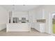Bright kitchen with island, stainless appliances, white cabinets, stylish backsplash, and outdoor views at 15240 Sw 43Rd Ct, Ocala, FL 34473