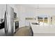 Well-lit kitchen with white cabinetry, stainless appliances, island with quartz countertop, and stylish faucet at 15240 Sw 43Rd Ct, Ocala, FL 34473