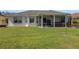 Well-maintained backyard featuring lush green grass and a covered lanai for outdoor enjoyment at 1646 Arash Cir, Port Orange, FL 32128