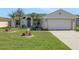 Well-maintained single Gathering home featuring green grass, a two car garage, and multiple palm trees at 1646 Arash Cir, Port Orange, FL 32128