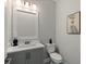Elegant powder room with gray vanity, quartz countertop, modern fixtures, and decorative artwork at 1807 Simonton Ave, Orlando, FL 32806