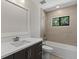 Bathroom with shower/tub combo, light tile and dark vanity at 1807 Simonton Ave, Orlando, FL 32806