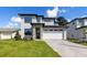 Contemporary two-story home featuring stone accents, a brick driveway, and a spacious two-car garage at 1807 Simonton Ave, Orlando, FL 32806