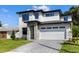 Contemporary two-story home featuring stone accents, a brick driveway, and a spacious two-car garage at 1807 Simonton Ave, Orlando, FL 32806