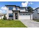 Contemporary two-story home featuring stone accents, a brick driveway, and a spacious two-car garage at 1807 Simonton Ave, Orlando, FL 32806