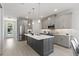 Bright kitchen showcasing stainless steel appliances, a dark island, gray cabinetry, pendant lighting, and hardwood floors at 1807 Simonton Ave, Orlando, FL 32806