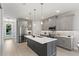 Bright kitchen showcasing stainless steel appliances, a dark island, gray cabinetry, pendant lighting, and hardwood floors at 1807 Simonton Ave, Orlando, FL 32806