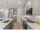 Modern kitchen with stainless steel appliances, gray cabinets, marble backsplash, and a large island at 1807 Simonton Ave, Orlando, FL 32806