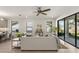 Open-concept living room with light wood floors, a ceiling fan and sliding glass doors to the backyard at 1807 Simonton Ave, Orlando, FL 32806