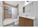 Tiled bathroom with a shower-tub combo, mosaic window, vanity, and mirror at 1866 Matterhorn Dr, Orlando, FL 32818