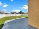 View of a backyard with a concrete patio, green grass, and a white privacy fence under a blue sky at 196 Westmoreland Cir, Kissimmee, FL 34744