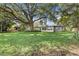 Sprawling backyard with lush green lawn, mature trees, and a serene hot tub area at 2913 Carmia Dr, Orlando, FL 32806