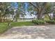 Lakeside backyard oasis featuring a stone patio, mature trees, and scenic water views provides a serene escape and natural beauty at 2913 Carmia Dr, Orlando, FL 32806