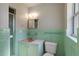 Vintage bathroom with green tile, updated fixtures, and natural light combines charm with functionality in this timeless space at 2913 Carmia Dr, Orlando, FL 32806