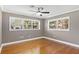 Cozy bedroom features hardwood floors, a ceiling fan, and sunny windows offering peaceful neighborhood views at 2913 Carmia Dr, Orlando, FL 32806