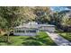 Charming single-story home with a well-manicured lawn, mature trees, and an attached two-car garage at 2913 Carmia Dr, Orlando, FL 32806