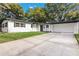 Inviting single-story home with a large driveway, lush lawn, and attached garage at 2913 Carmia Dr, Orlando, FL 32806