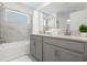 Bathroom featuring a double vanity with modern fixtures, a tub, and white marble tile at 2945 Simile St, Kissimmee, FL 34746