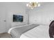 Well-lit bedroom featuring a comfortable bed, modern lighting, a television, and neutral tones throughout at 2945 Simile St, Kissimmee, FL 34746