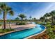 Lazy river winding through a resort-style community with tropical landscaping and blue skies at 2945 Simile St, Kissimmee, FL 34746