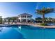 Community pool and clubhouse with lounge chairs under a blue sky at 2945 Simile St, Kissimmee, FL 34746